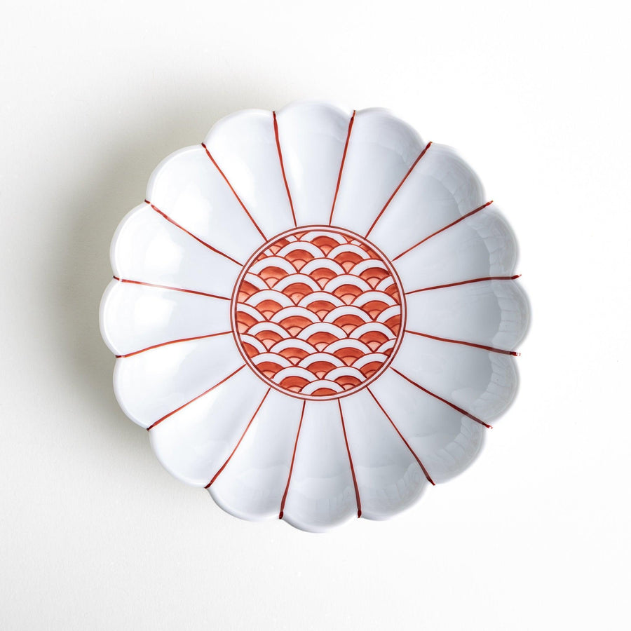 A scalloped-edged green plate with a blue and white wave pattern in the center.