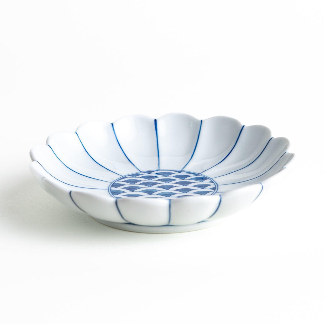 A scalloped-edged green plate with a blue and white wave pattern in the center.