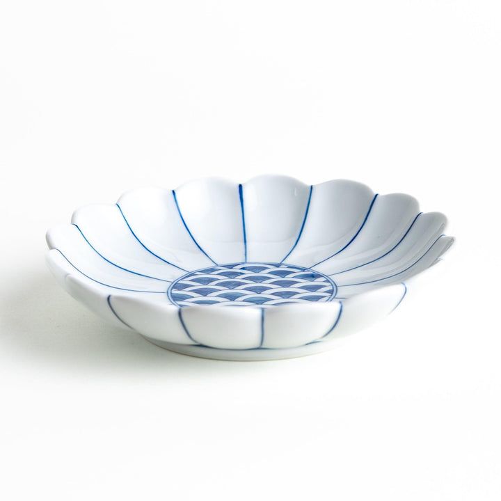 A scalloped-edged green plate with a blue and white wave pattern in the center.