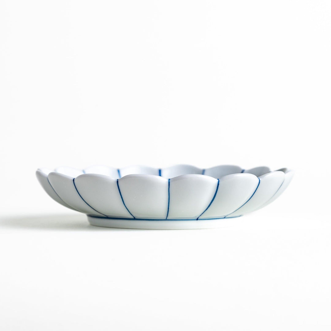 A scalloped-edged green plate with a blue and white wave pattern in the center.