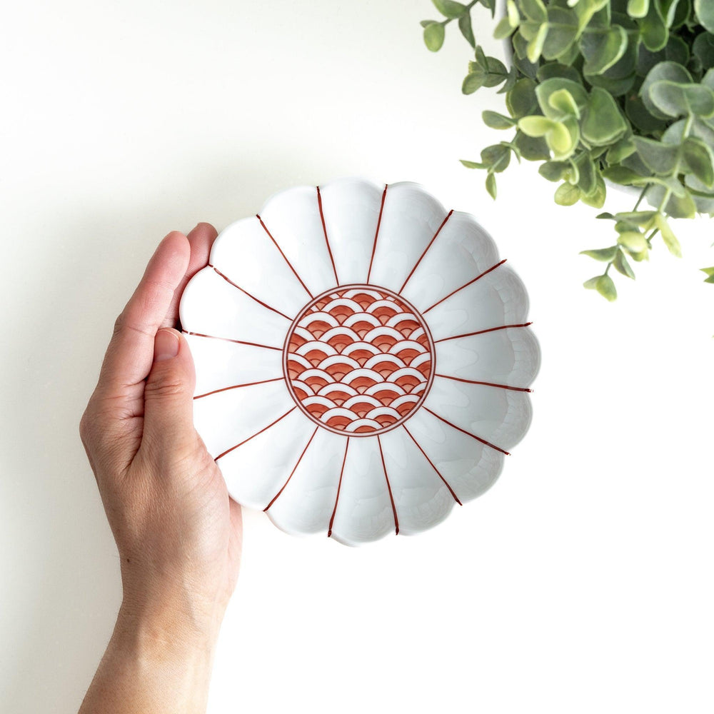 A scalloped-edged green plate with a blue and white wave pattern in the center.