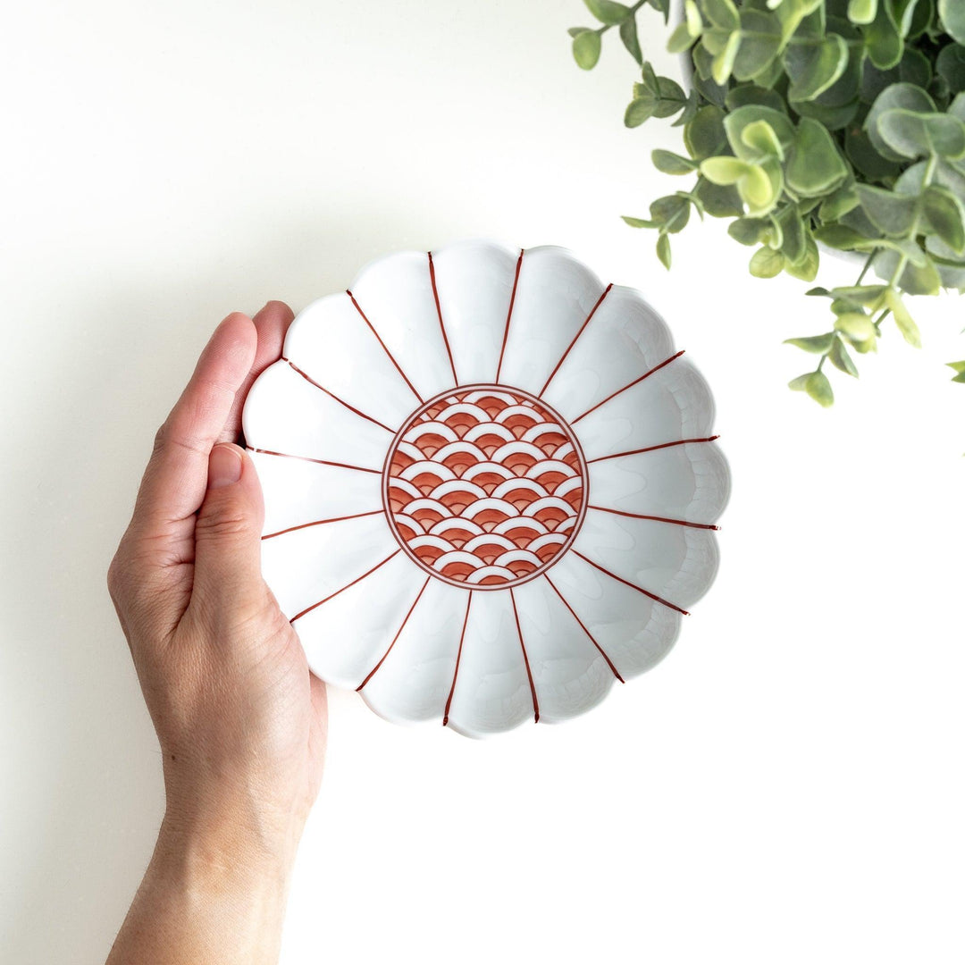 A scalloped-edged green plate with a blue and white wave pattern in the center.