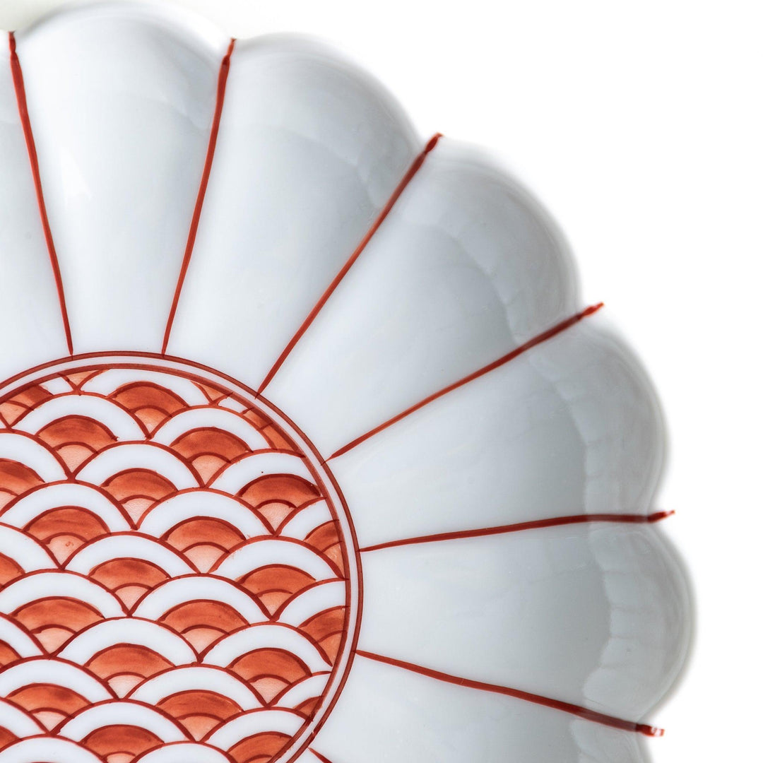 A scalloped-edged green plate with a blue and white wave pattern in the center.