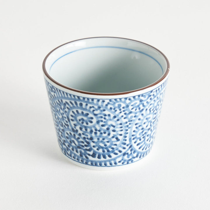 A small cylindrical cup featuring a detailed blue spiral pattern on a white base.