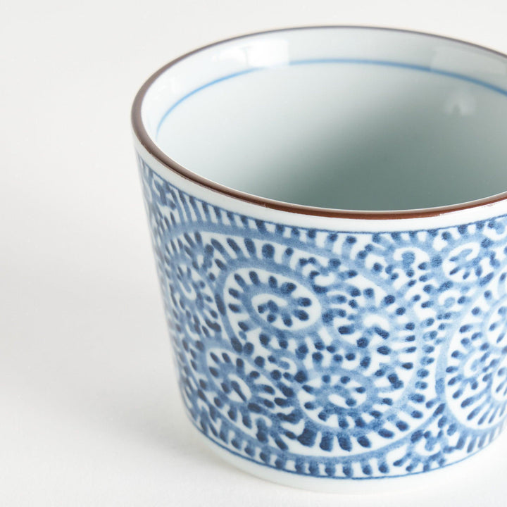 A small cylindrical cup featuring a detailed blue spiral pattern on a white base.