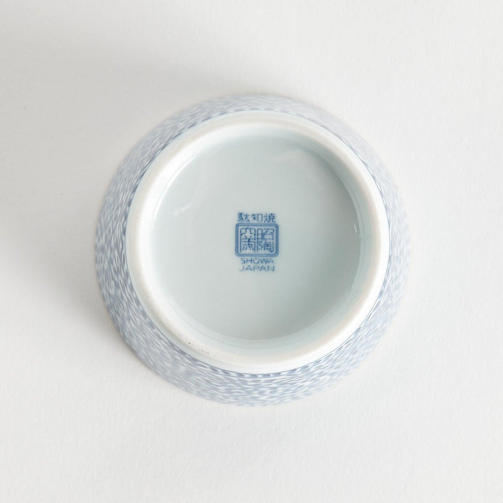 A small cylindrical cup featuring a detailed blue spiral pattern on a white base.