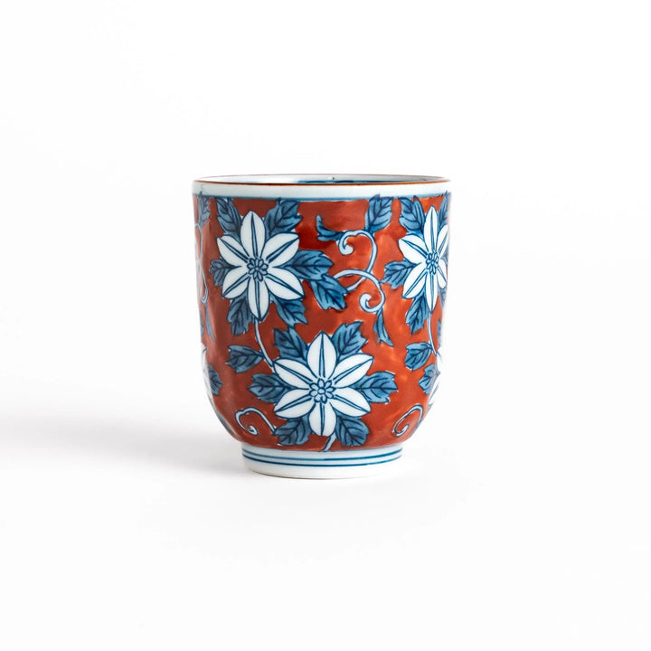 Hand painted teacup with red background and blue clematis flowers adding charm to Japanese tea service.