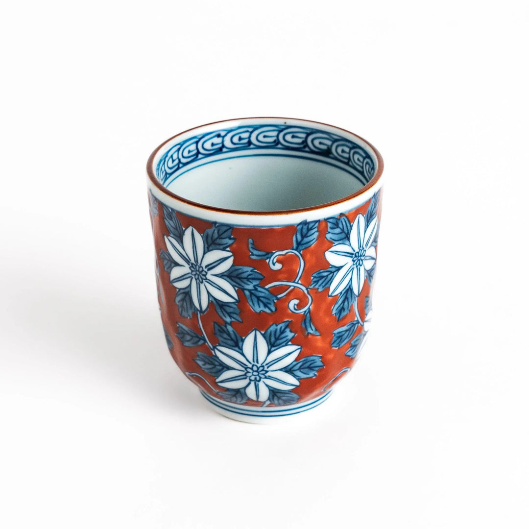 Hand painted teacup with red background and blue clematis flowers adding charm to Japanese tea service.