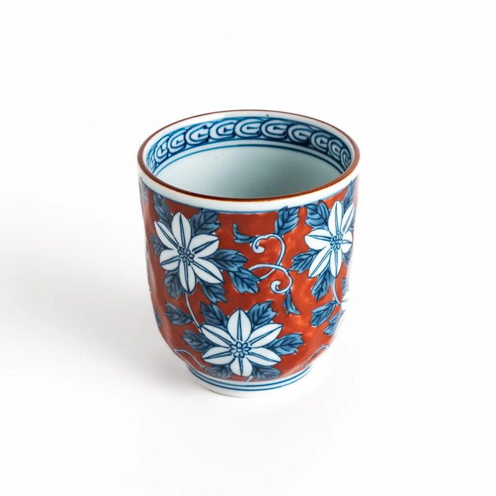 Hand painted teacup with red background and blue clematis flowers adding charm to Japanese tea service.