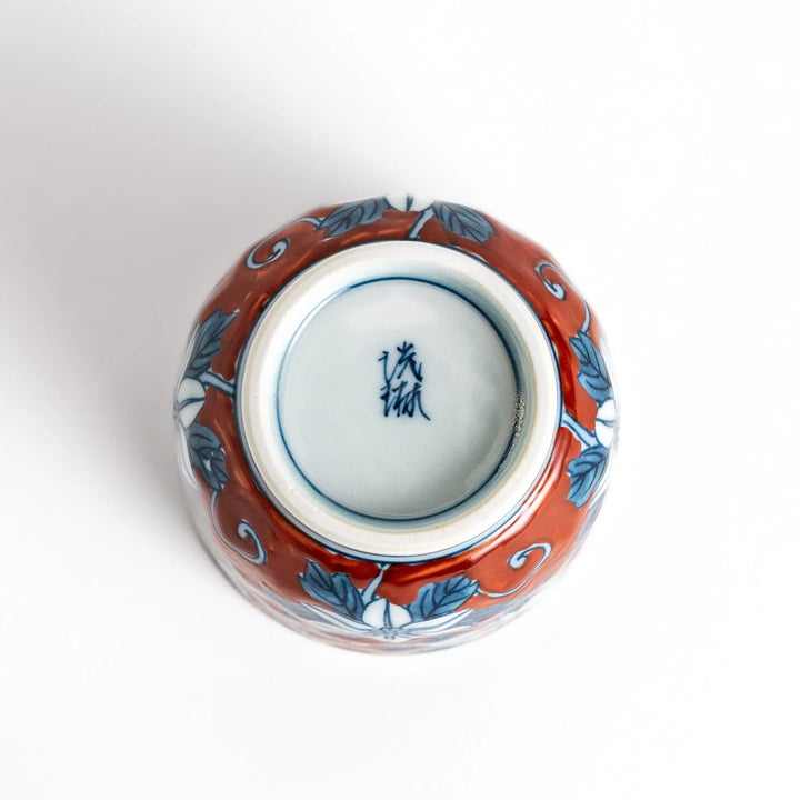 Hand painted teacup with red background and blue clematis flowers adding charm to Japanese tea service.