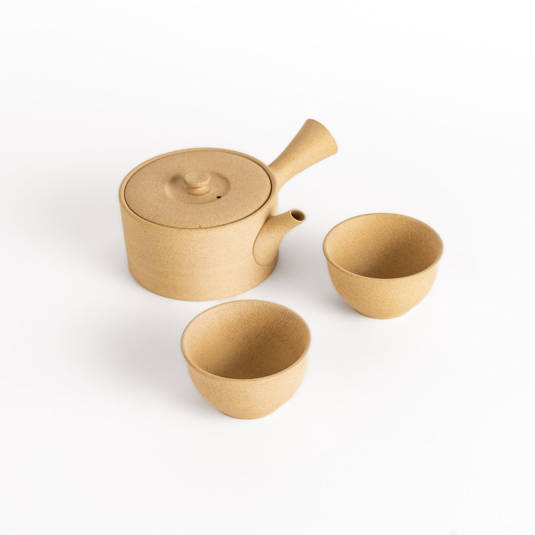 Elegant beige tea set featuring a round teapot with spout and matching bowls, perfect for enjoying your favorite tea.