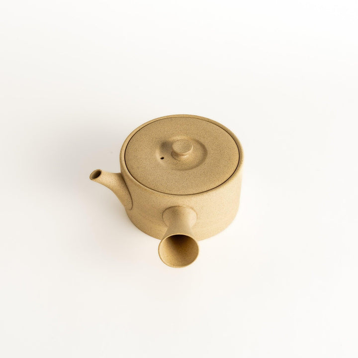 Minimalist beige teapot with a horizontal spout and handle design, crafted from textured ceramic, perfect for contemporary tea service.