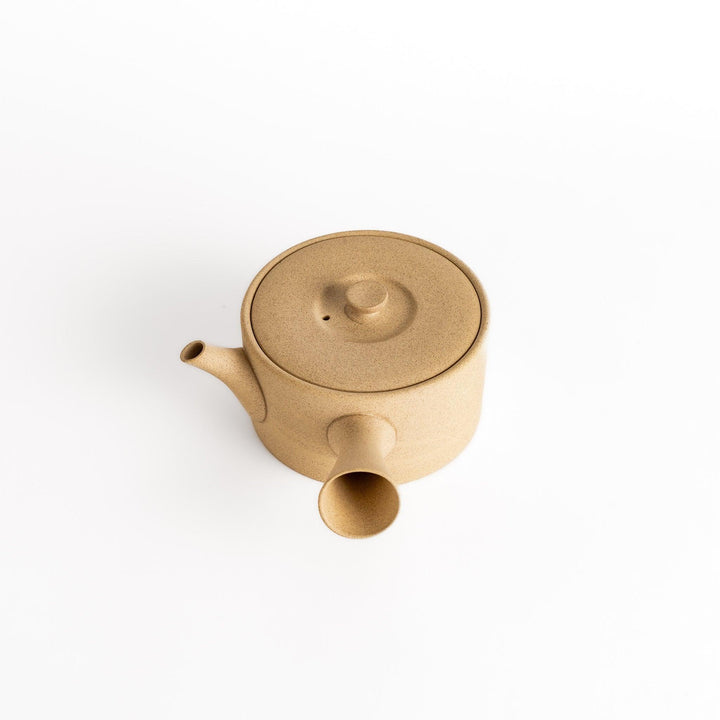 Slightly angled view of the beige teapot, focusing on its elegant proportions and horizontal spout and handle.