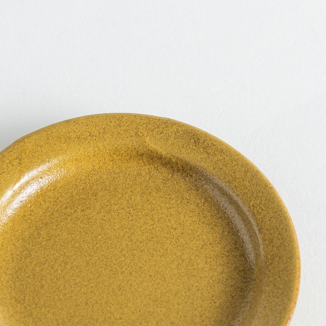 Yellow plate with a natural matte texture, accented by the handmade look of the uneven glaze on its edge.