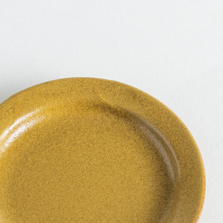 Yellow plate with a natural matte texture, accented by the handmade look of the uneven glaze on its edge.