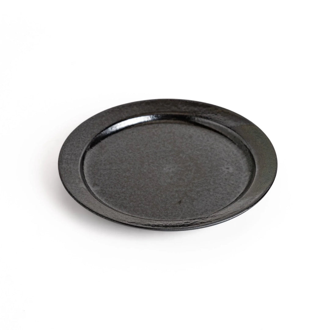 Black ceramic dinner plate with glossy finish and smooth texture offering minimalist elegance to any dining table.