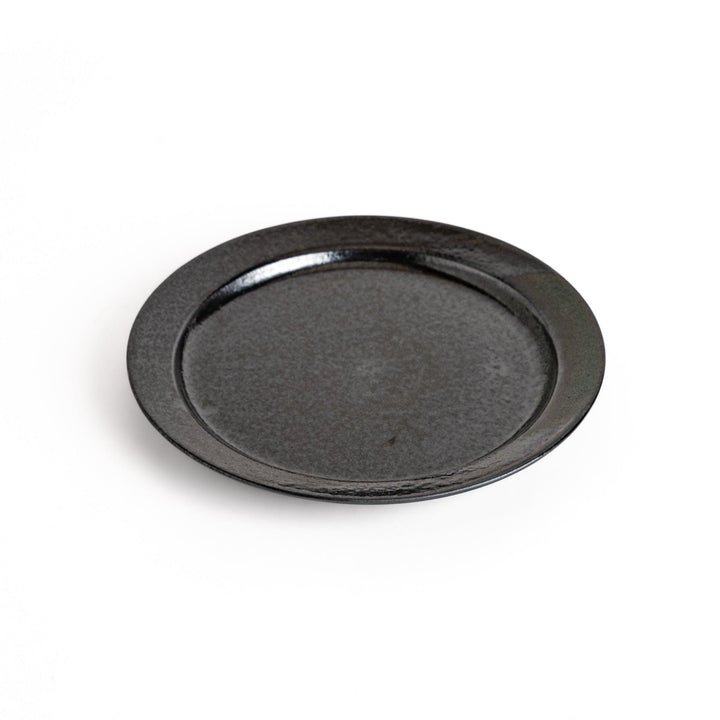 Black ceramic dinner plate with glossy finish and smooth texture offering minimalist elegance to any dining table.