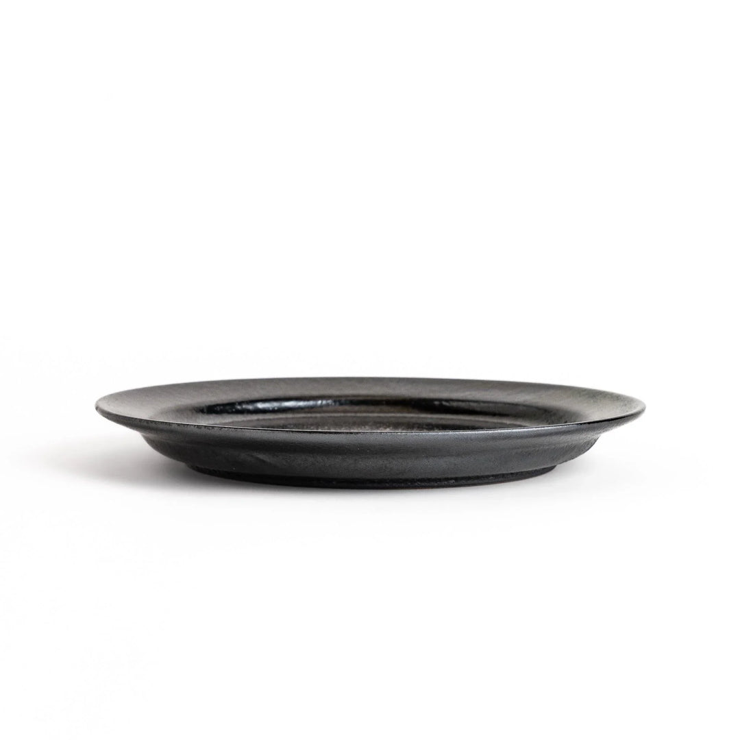 Black ceramic dinner plate with glossy finish and smooth texture offering minimalist elegance to any dining table.