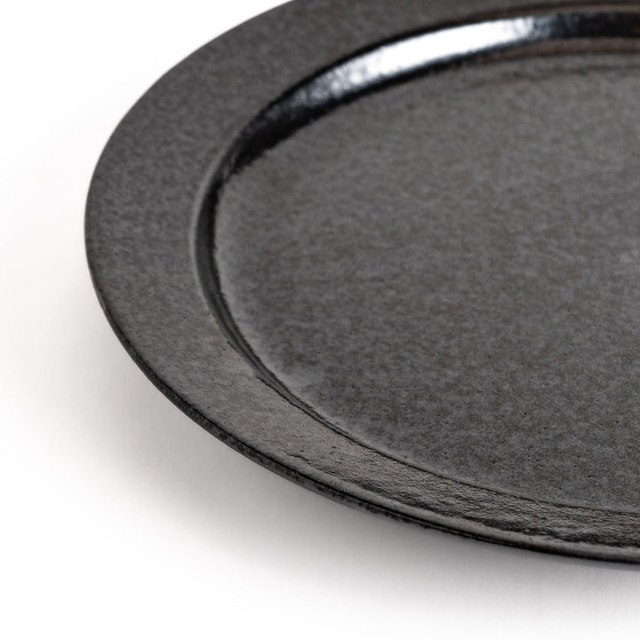 Black ceramic dinner plate with glossy finish and smooth texture offering minimalist elegance to any dining table.