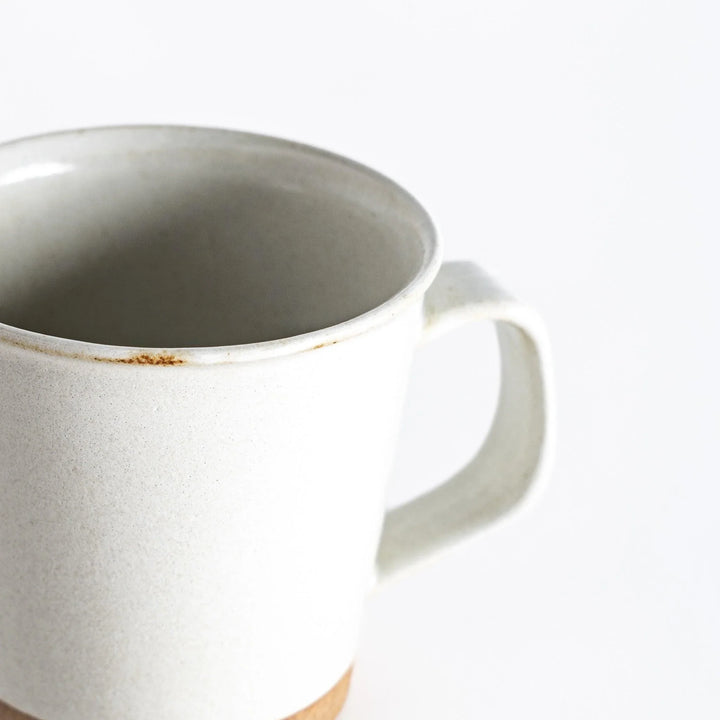 Colorful mug in blue red green yellow white or black with glossy finish and natural clay base on wooden block.