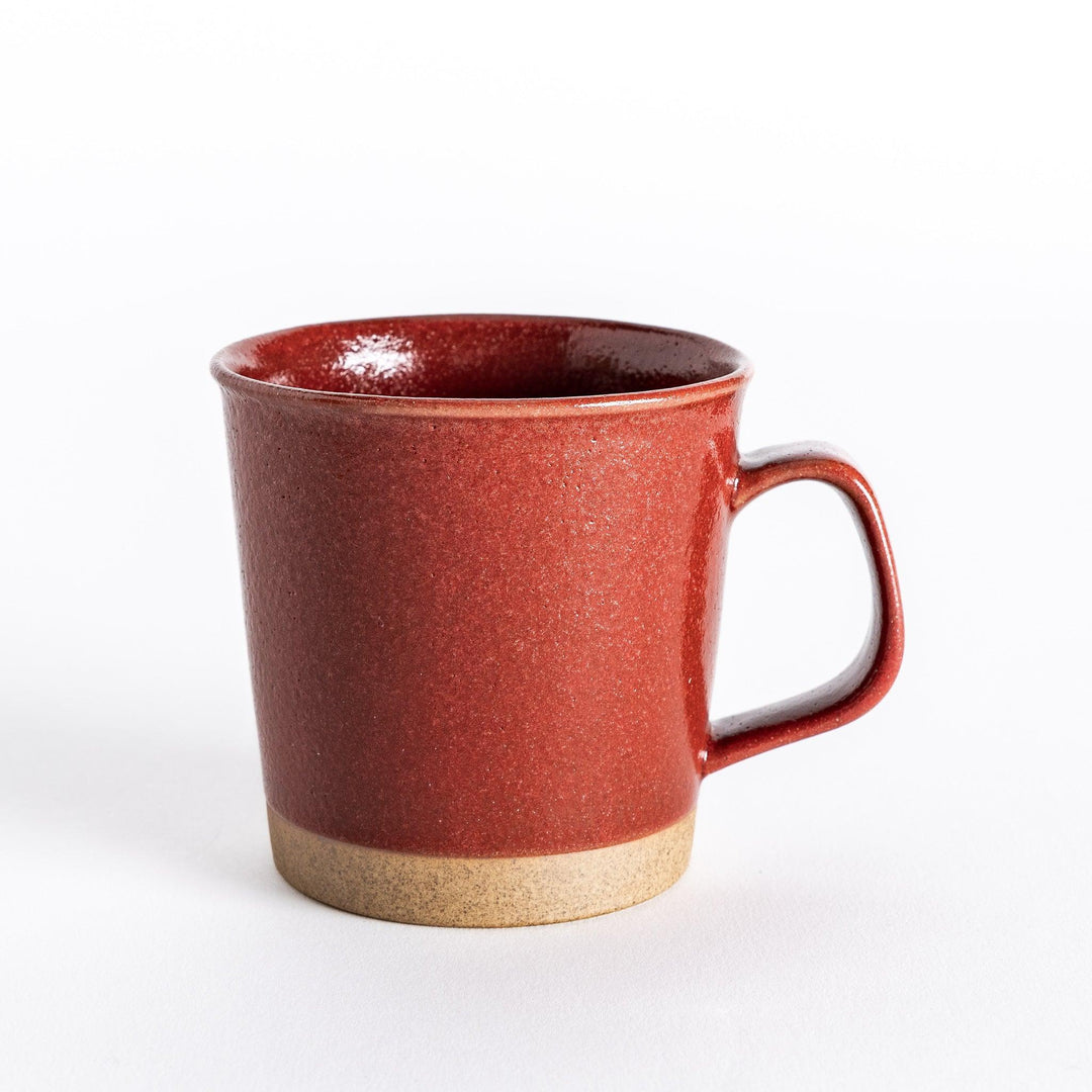 Front view of a red ceramic mug with a smooth glossy finish and neutral-toned base, highlighting its minimalist design.