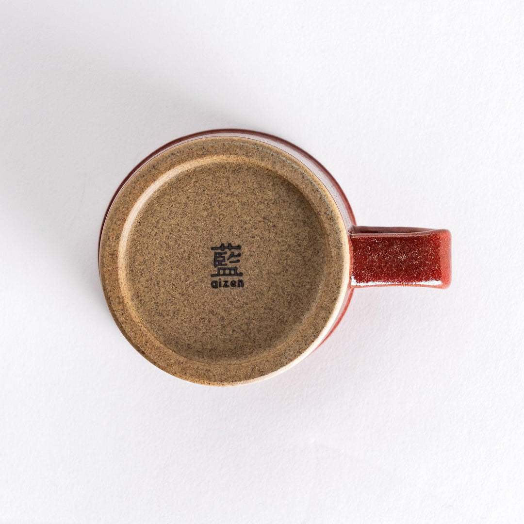 Bottom view of a red ceramic mug featuring a smooth neutral-toned base with a slightly textured finish.