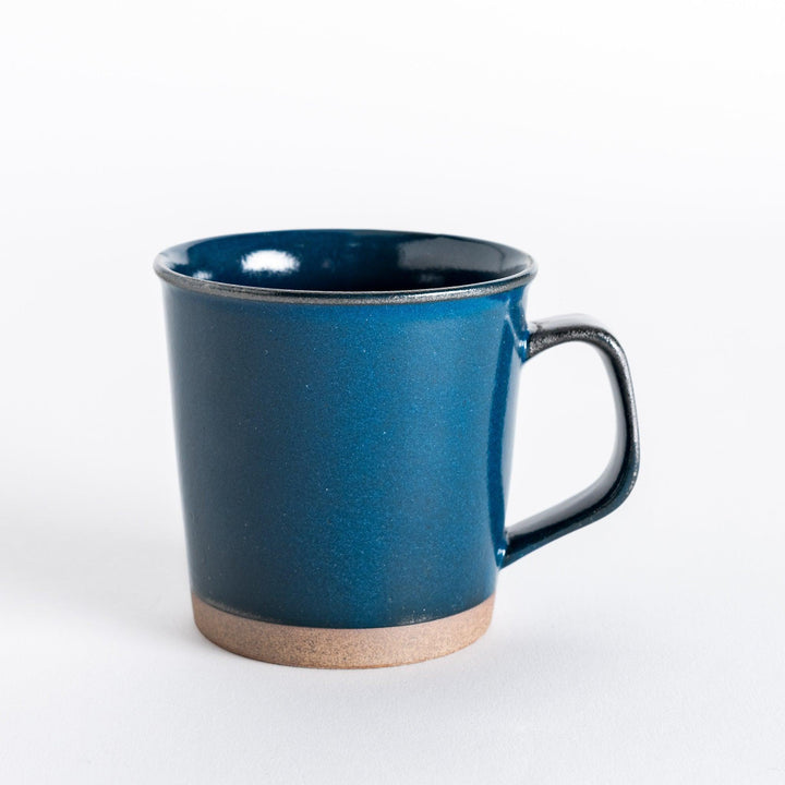 Front view of a blue ceramic mug with a glossy finish and neutral-toned base, showcasing its clean, minimalist design.