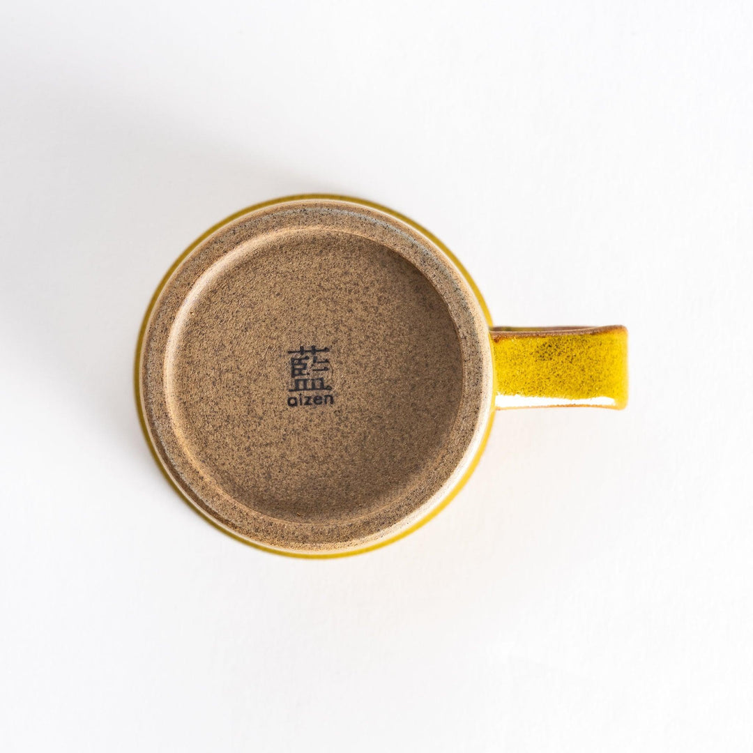 Colorful mug in blue red green yellow white or black with glossy finish and natural clay base on wooden block.