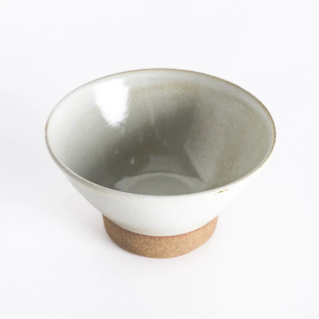 White ceramic rice bowl with a matte glaze, photographed at an angle to display its elegant form.