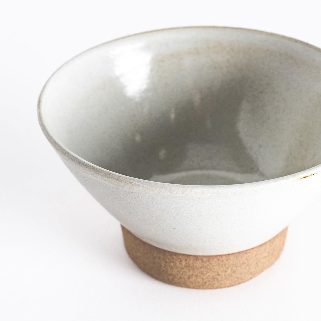 Close-up view of the white ceramic rice bowl, emphasizing its subtle texture and neutral base.