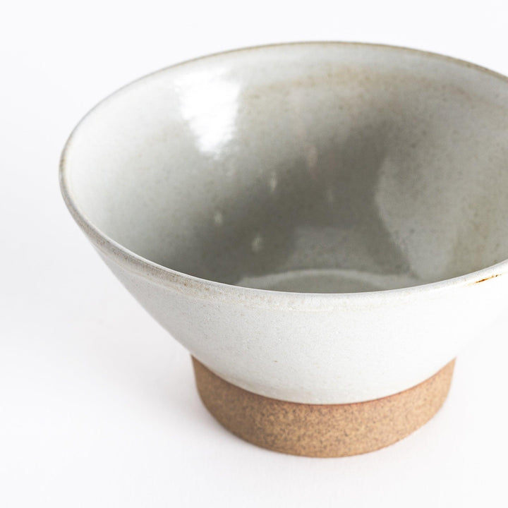 Close-up view of the white ceramic rice bowl, emphasizing its subtle texture and neutral base.