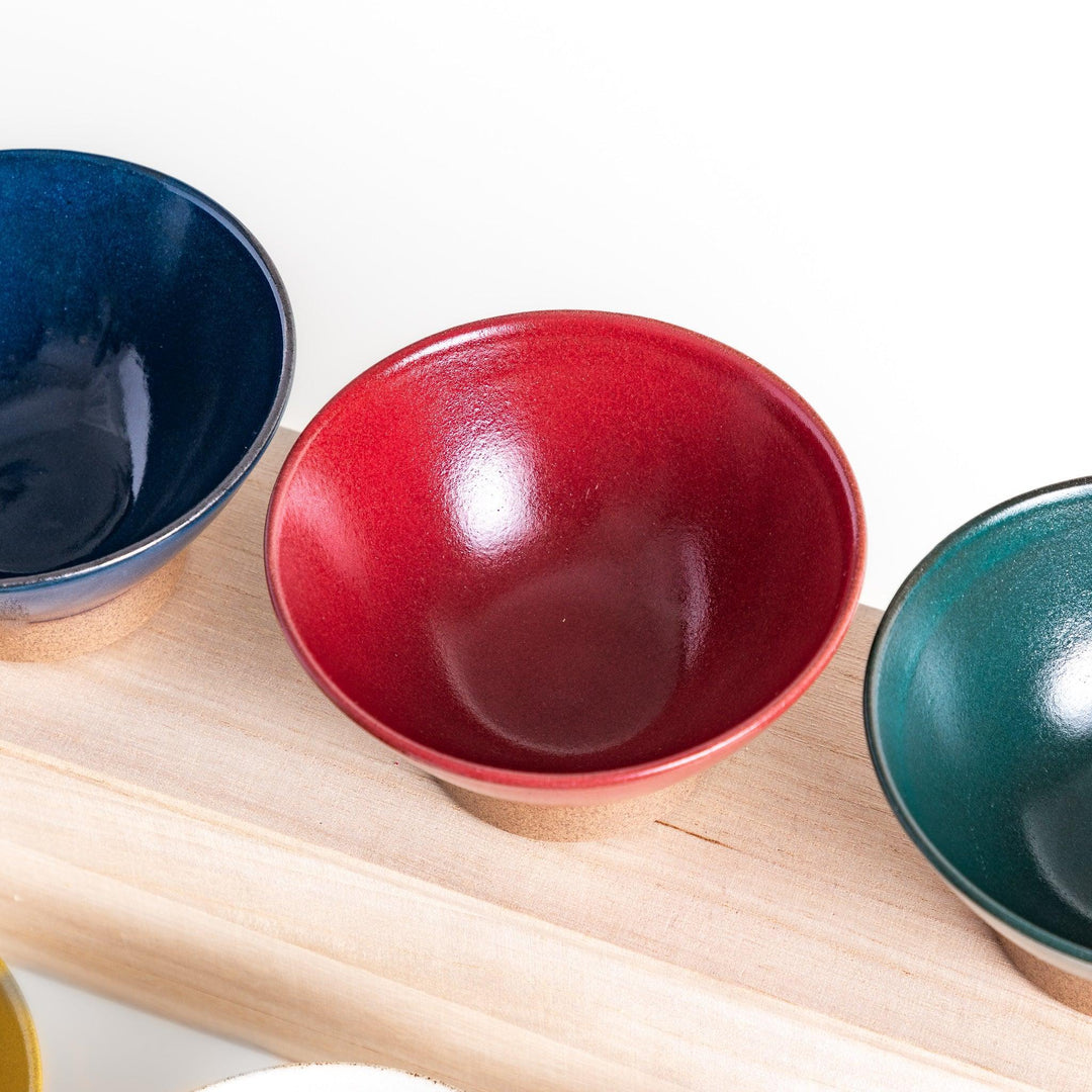 Ceramic rice bowl with smooth glossy finish and natural clay base placed on wooden block for modern dining.