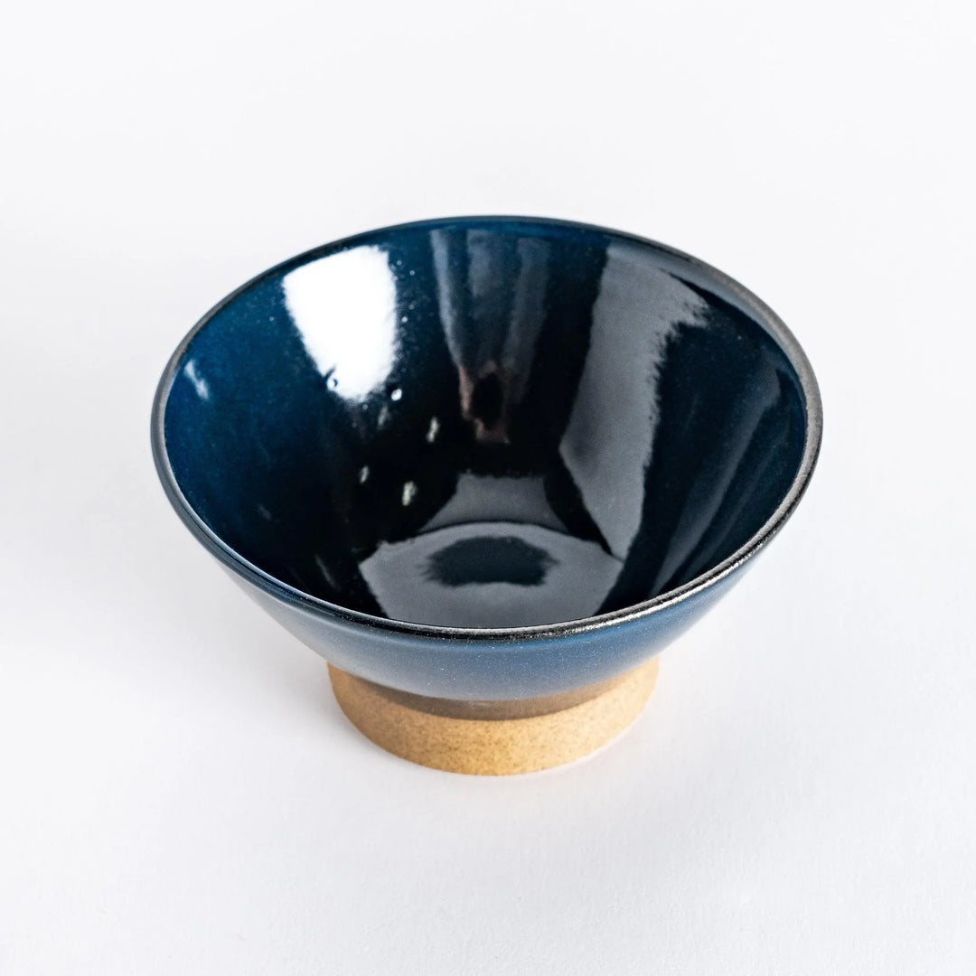Blue ceramic rice bowl with a glossy glaze, photographed at a slight angle to highlight its elegant curve and shine.