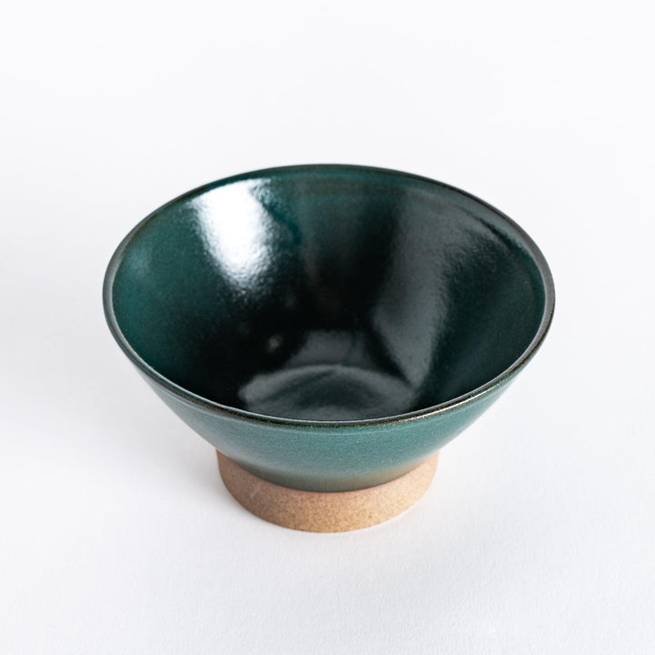 Green ceramic rice bowl with a glossy glaze, photographed at an angle to highlight its deep color and shape.