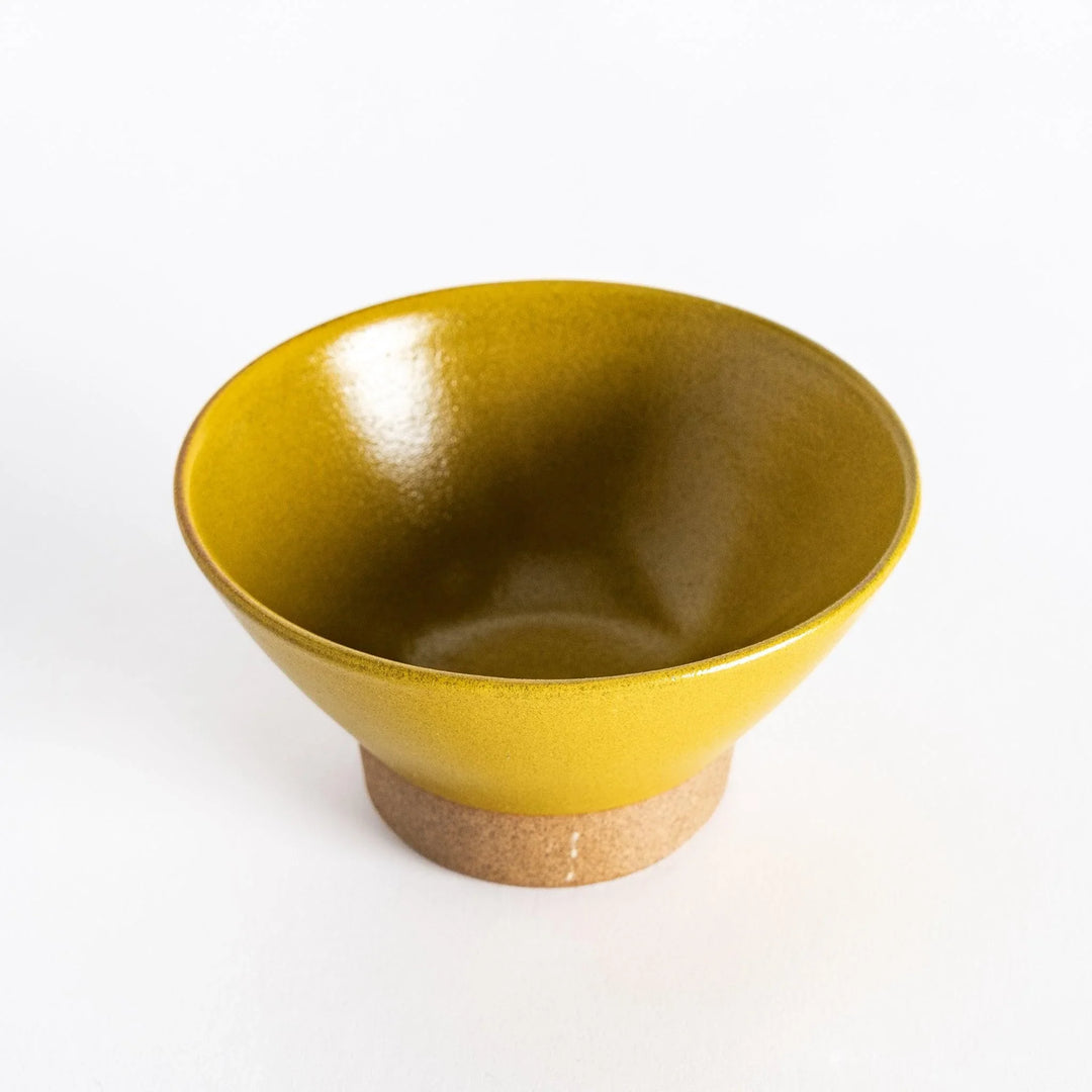 Yellow ceramic rice bowl with a glossy glaze, photographed at a slight angle to highlight its form and bright color.