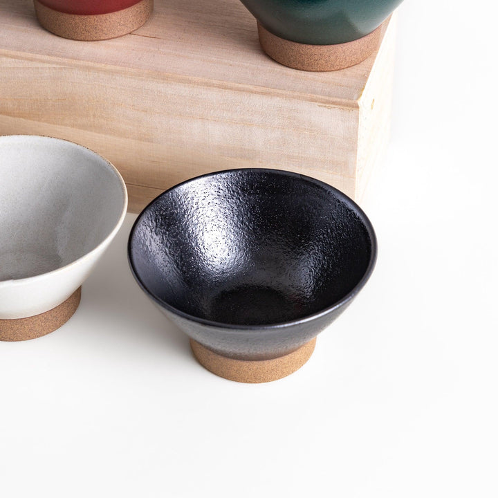 Ceramic rice bowl with smooth glossy finish and natural clay base placed on wooden block for modern dining.