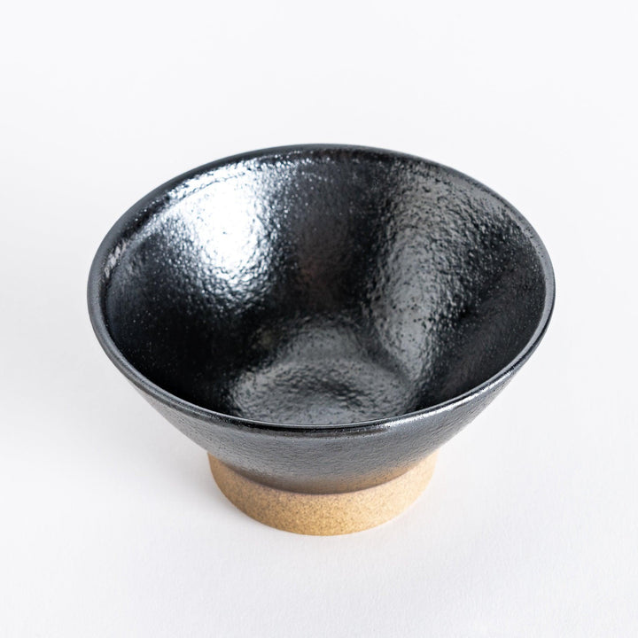 Black ceramic rice bowl with a glossy glaze, photographed at a slight angle to highlight its curves and design.