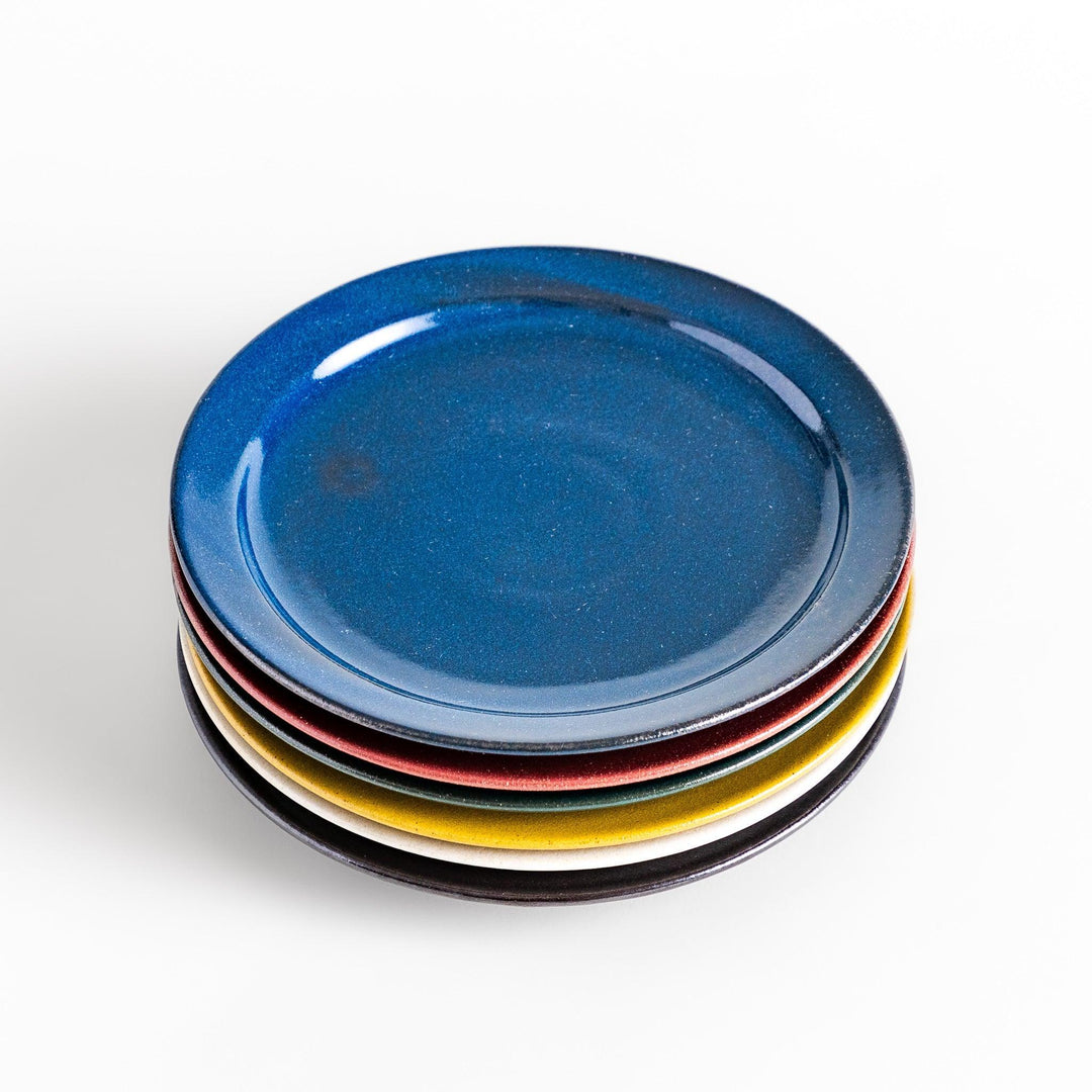 Colorful salad plate in blue red yellow white or black with smooth glossy finish adding vibrant touch to table.