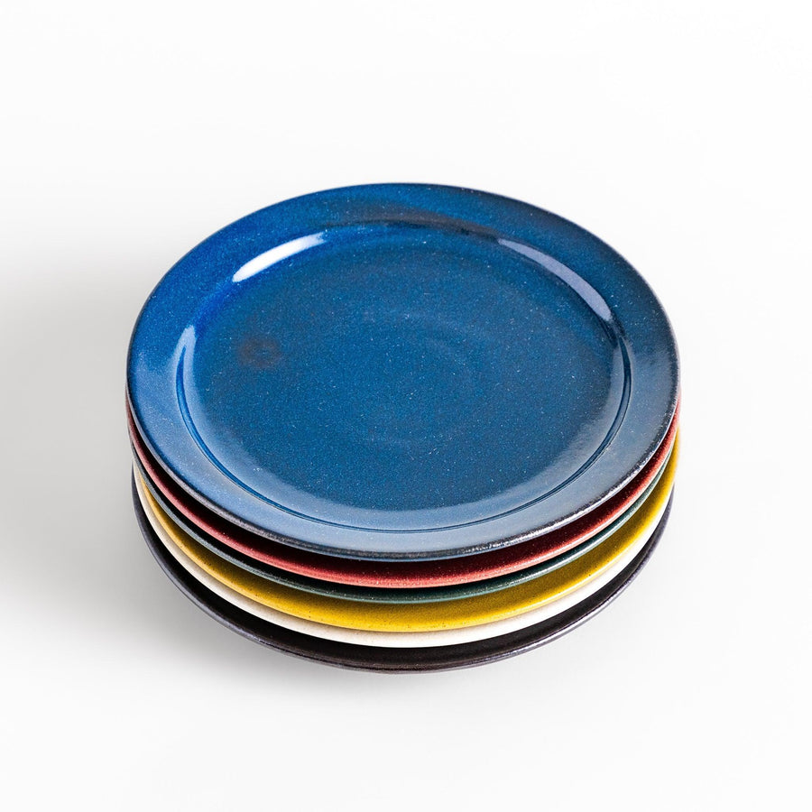 Colorful salad plate in blue red yellow white or black with smooth glossy finish adding vibrant touch to table.