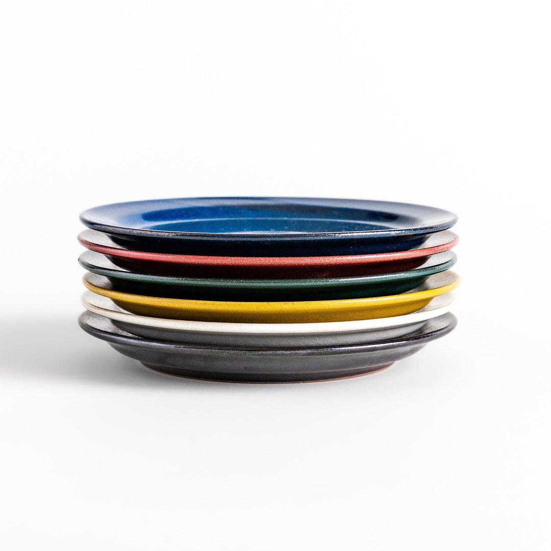 Colorful salad plate in blue red yellow white or black with smooth glossy finish adding vibrant touch to table.