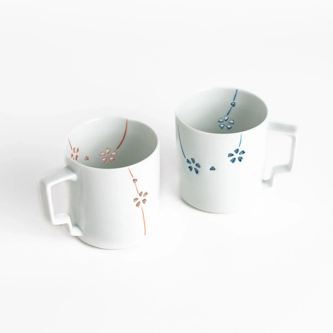 Ceramic mug pair with delicate red and blue floral designs perfect for adding elegance to your morning coffee.