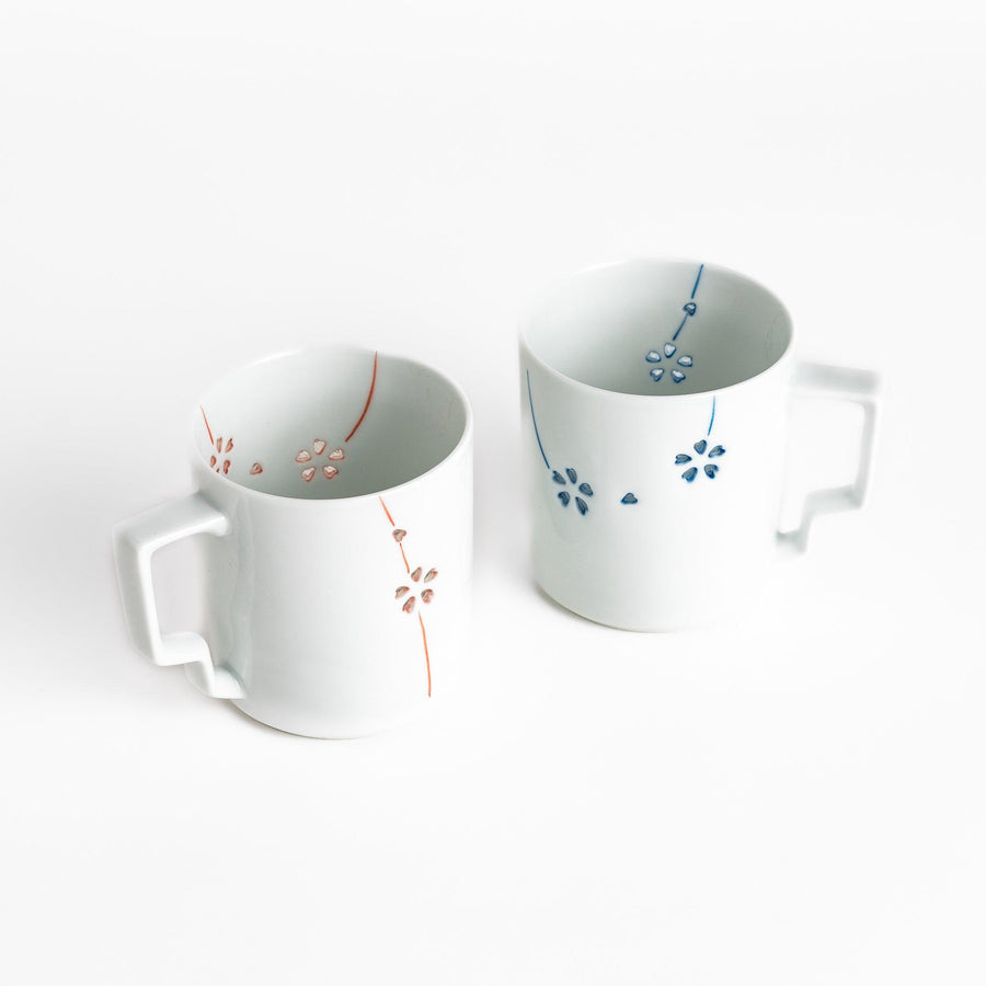 Ceramic mug pair with delicate red and blue floral designs perfect for adding elegance to your morning coffee.