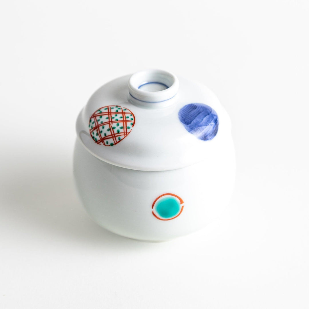 Japanese porcelain chawanmushi bowl with lid featuring colorful red blue and turquoise patterns on white background