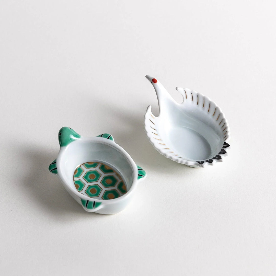 Turtle and crane shaped ceramic dishes with hexagon and wing patterns symbolizing longevity and harmony.