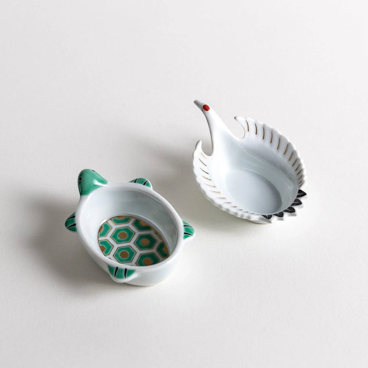 Turtle and crane shaped ceramic dishes with hexagon and wing patterns symbolizing longevity and harmony.