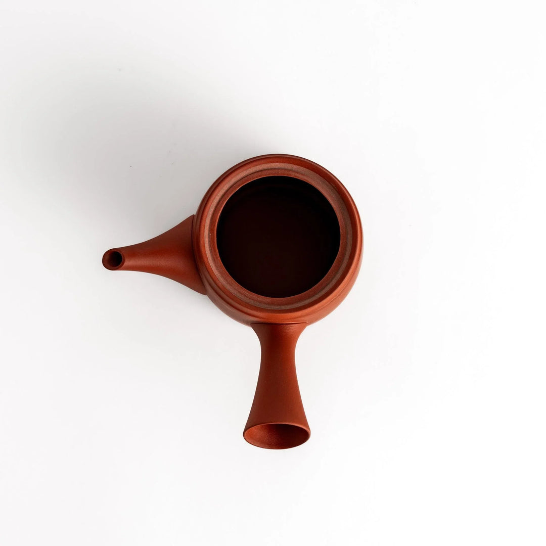 Crimson teapot with the lid removed, revealing the interior and functional design for optimal tea brewing.