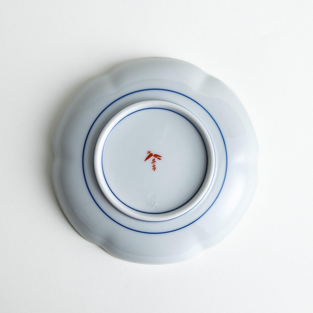 Round dessert plate with floral center and scalloped rim featuring red green and gold intricate patterns.