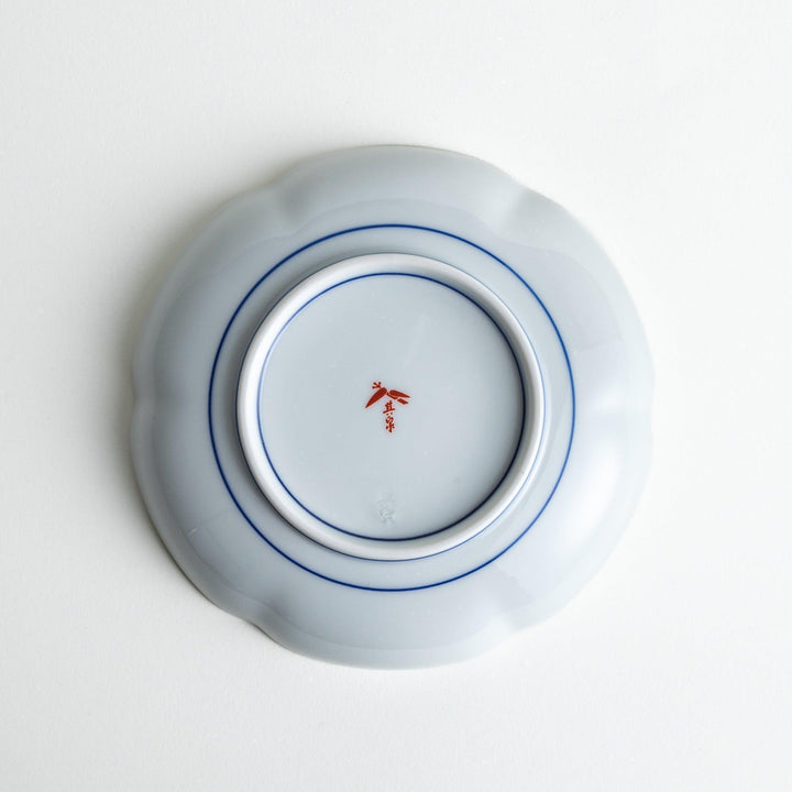 Round dessert plate with floral center and scalloped rim featuring red green and gold intricate patterns.