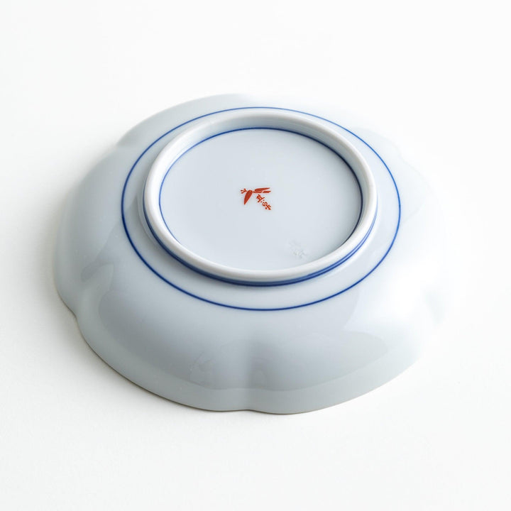 Round dessert plate with floral center and scalloped rim featuring red green and gold intricate patterns.