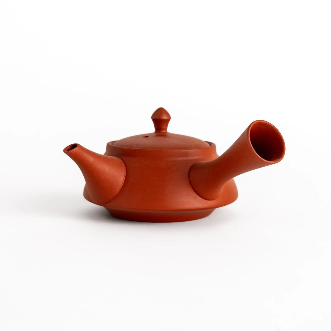 Crimson red teapot with smooth matte finish and rounded spout designed for elegant tea service.